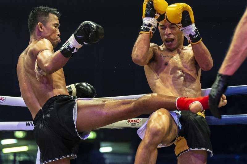 Muay Thai fighter Singdam Kiatmuu9 landing a shin kick against Christian Zahe